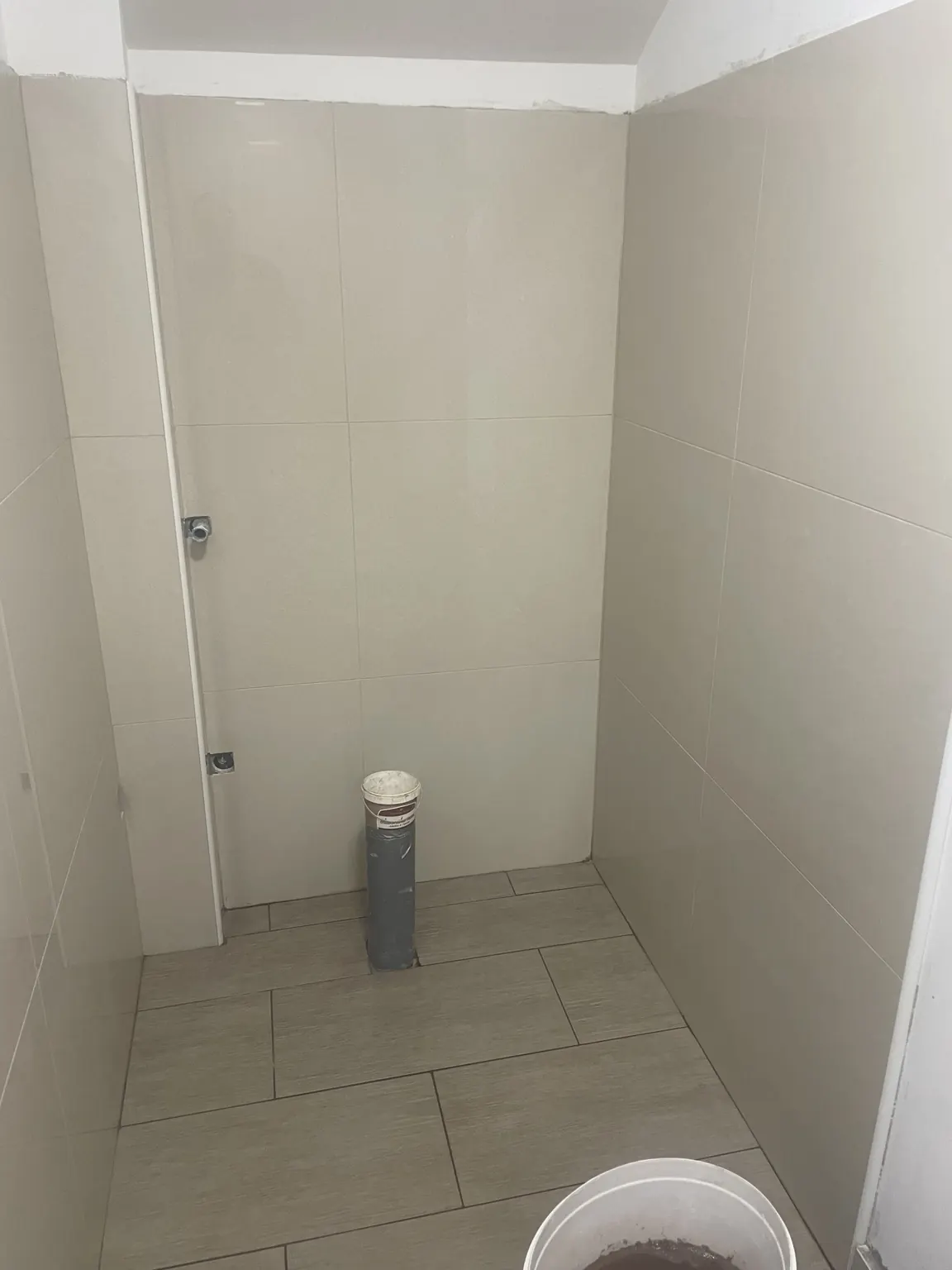 Postavljanje zidne i podne keramike u sanitarnom prostoru tijekom adaptacije kuće.