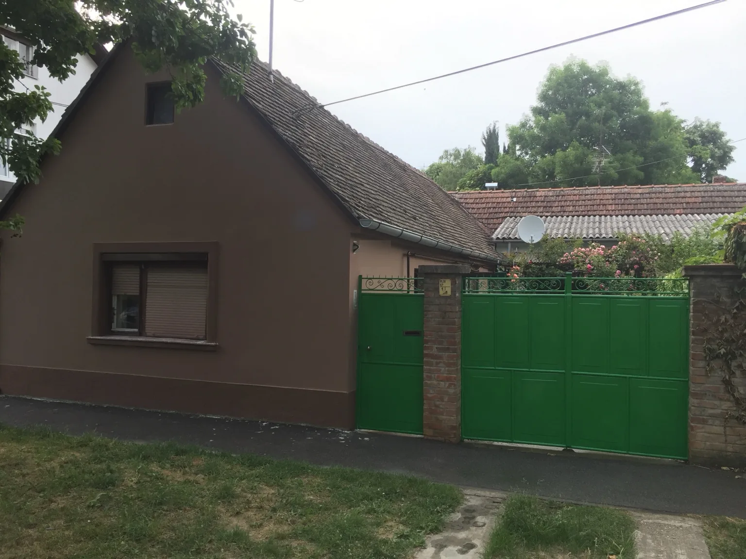 Ulična strana obiteljske kuće u Osijeku nakon obnove i bojanja fasade, cokla, stolarije i kapije.
