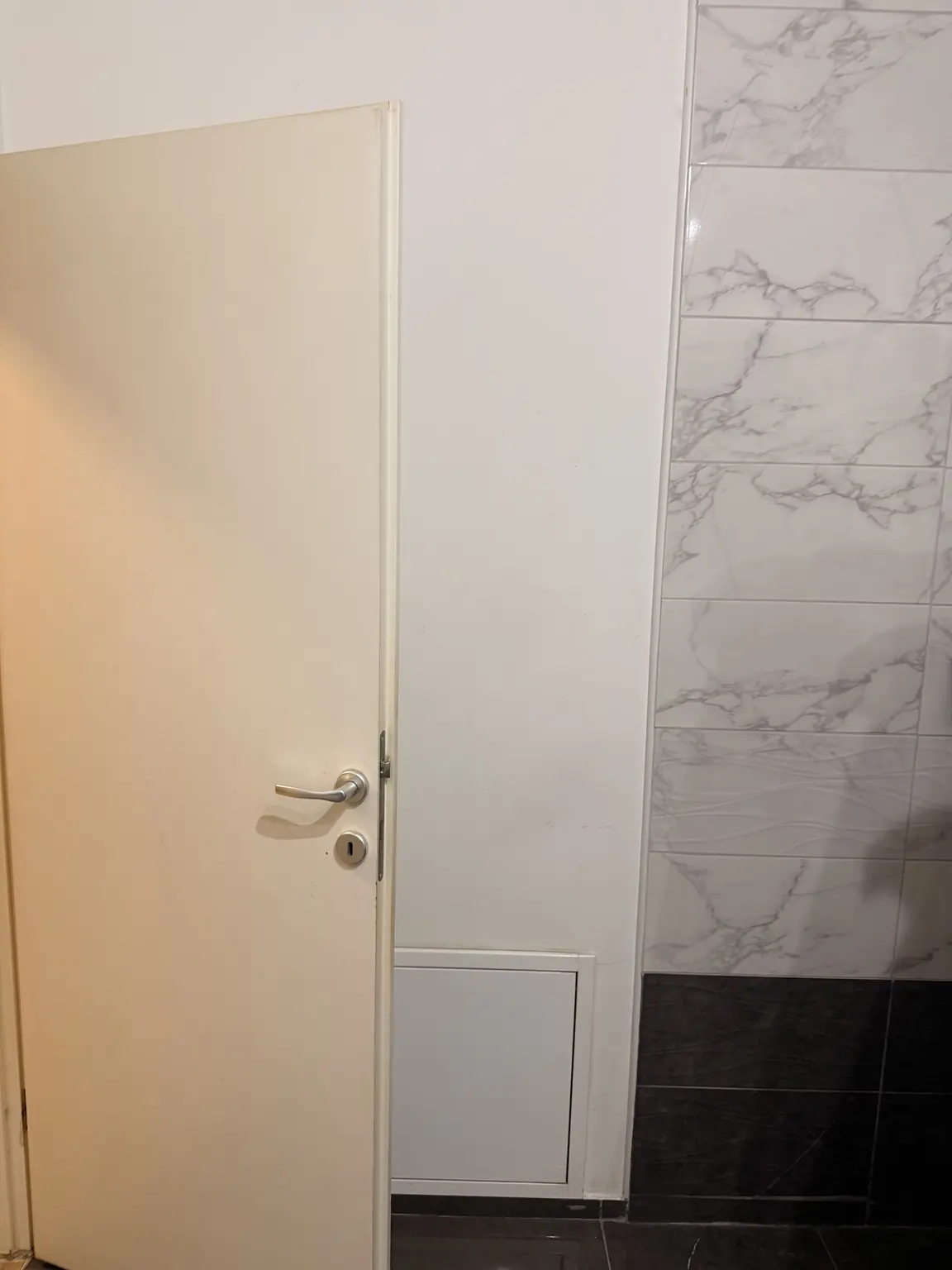 Detalj postojećih vrata i keramike prije završnog bojanja kupaonice u Osijeku.